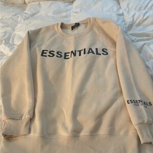 Sweatshirt says essentials and says fear of god on it